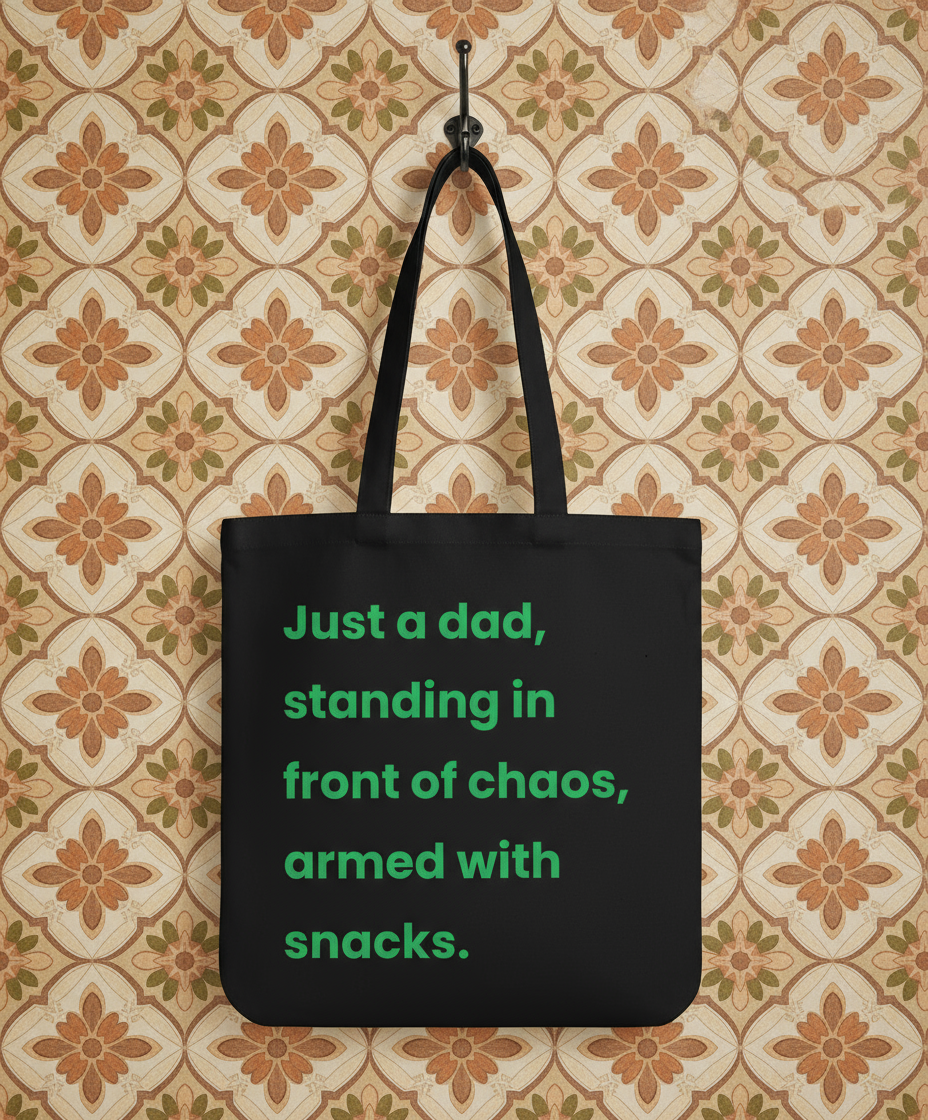 Black tote bag with green text on a floral-patterned wall