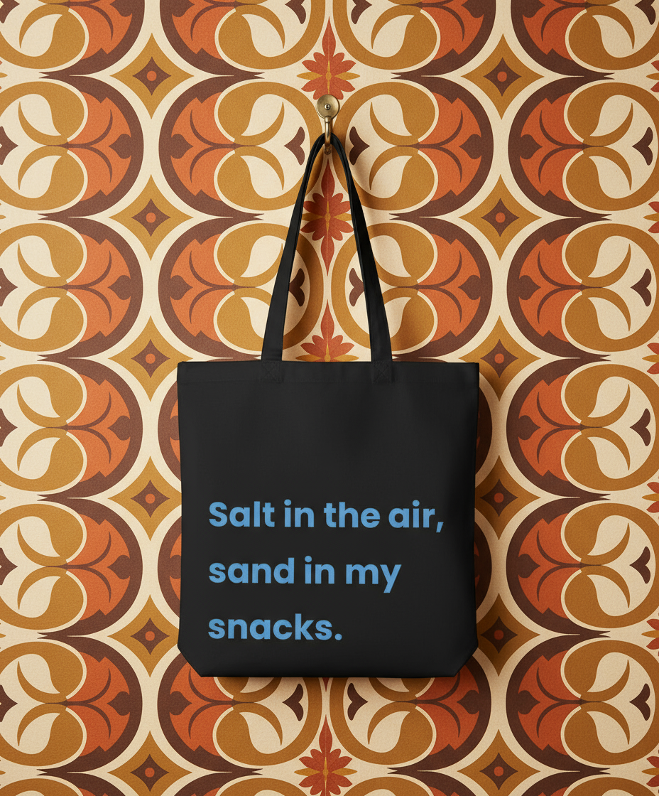 Black tote bag with blue text on a patterned wall
