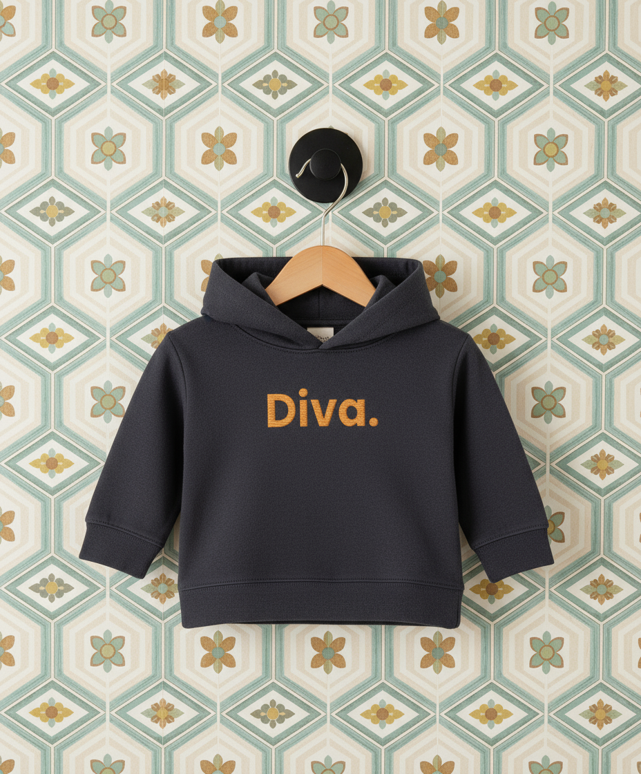 Navy hoodie with 'Diva.' text on a hanger against a patterned wall.