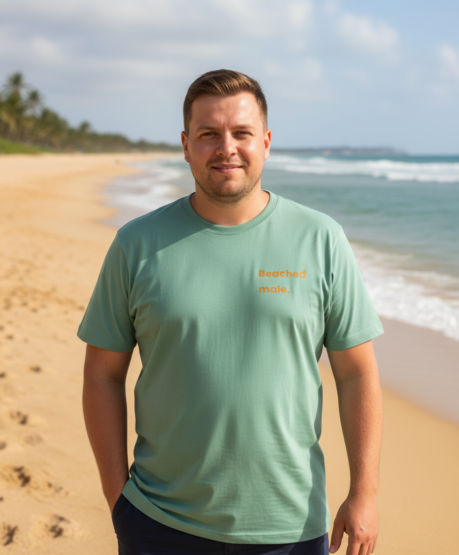 Man wearing a green t-shirt with text on a beach