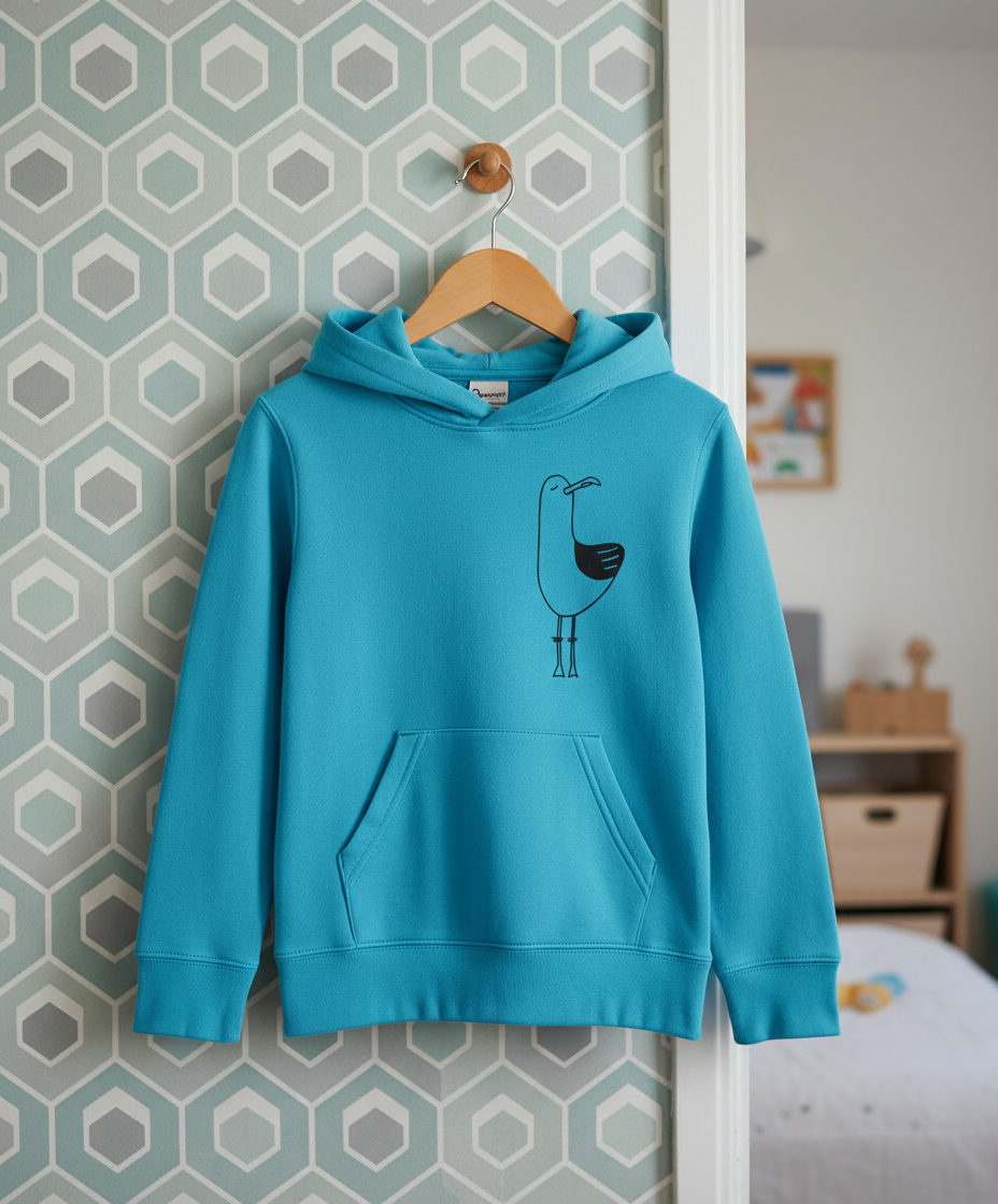 Blue hoodie with a bird design on a hanger against a geometric-patterned wall.