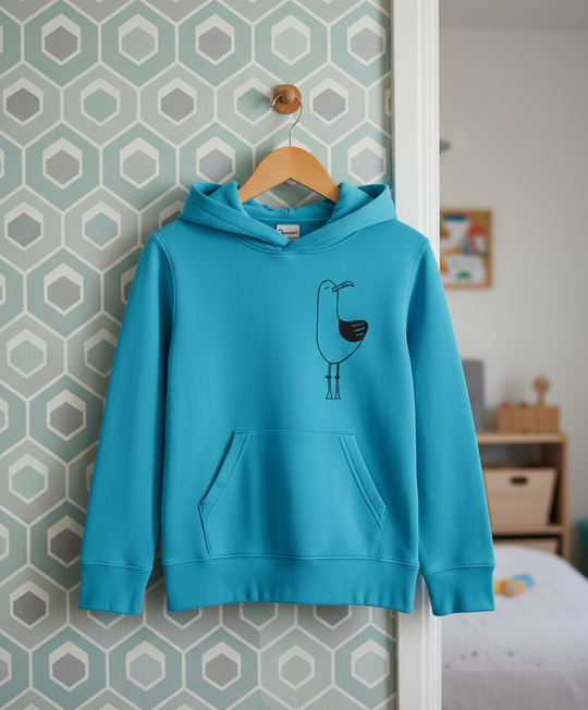 Blue hoodie with a bird design on a hanger against a geometric-patterned wall.