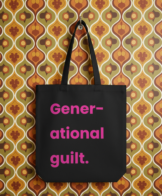 Black tote bag with 'Generational guilt' text on a patterned wall background