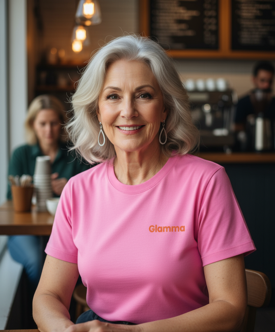 Woman wearing a pink shirt with 'Glamma' logo in a coffee shop setting