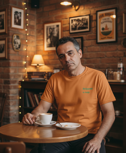 Man looking tired sitting at a table in a cosy bar with a cup of coffee