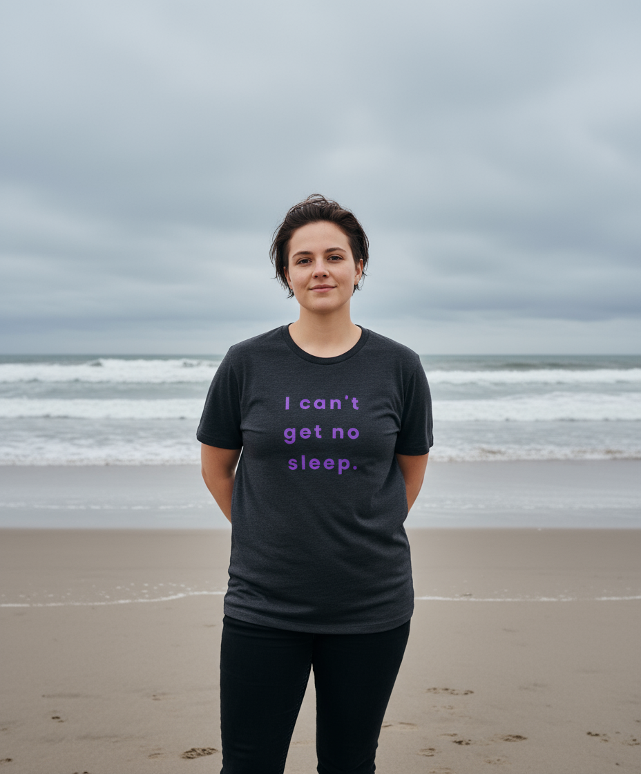 Person wearing a black t-shirt with text on a beach