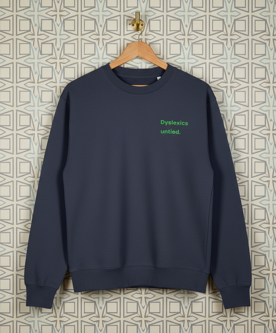 Navy blue sweatshirt with 'Dyslexics untied.' text on a patterned wall background