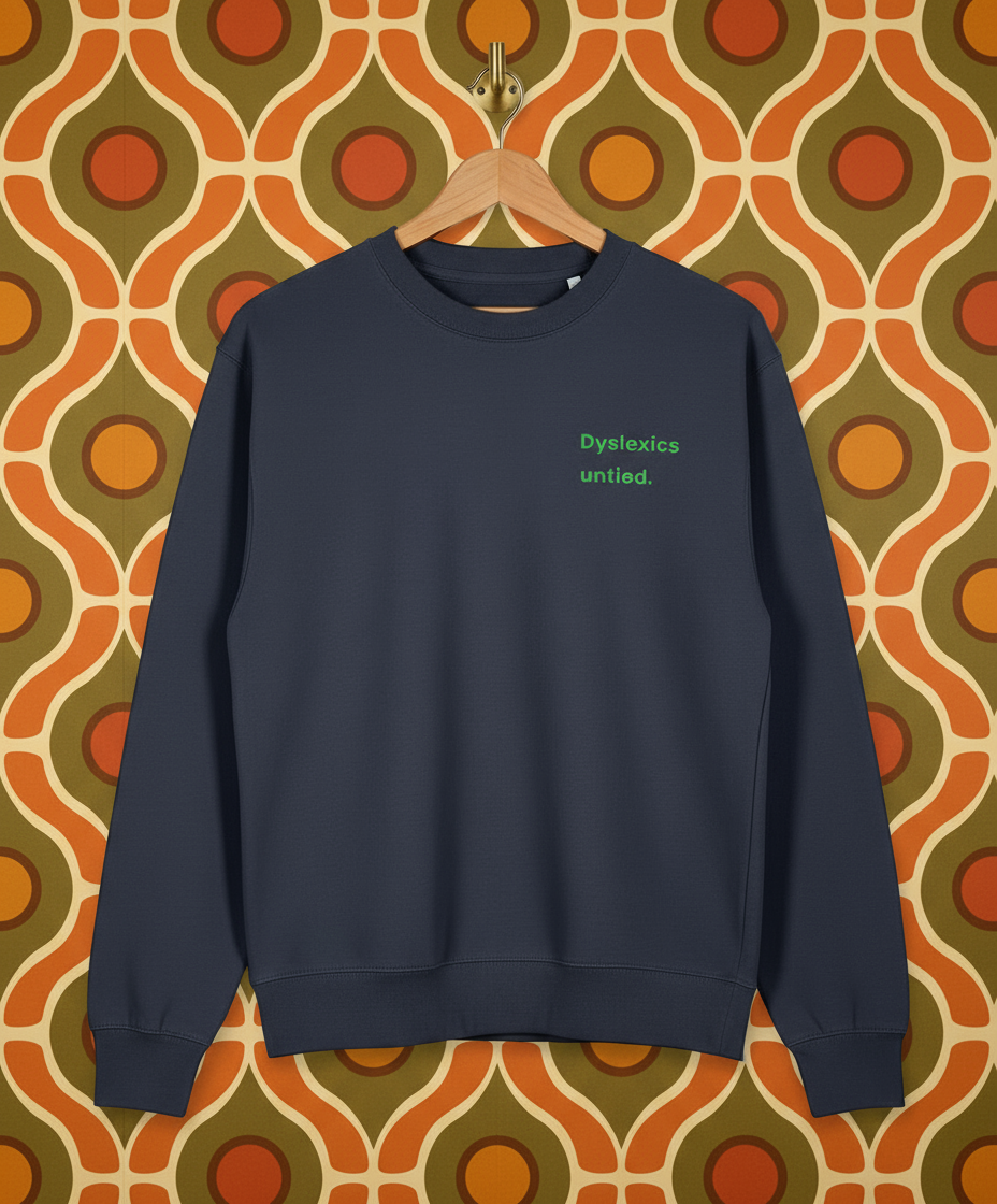 Navy blue sweatshirt with 'Dyslexics untied.' text on a patterned wall background