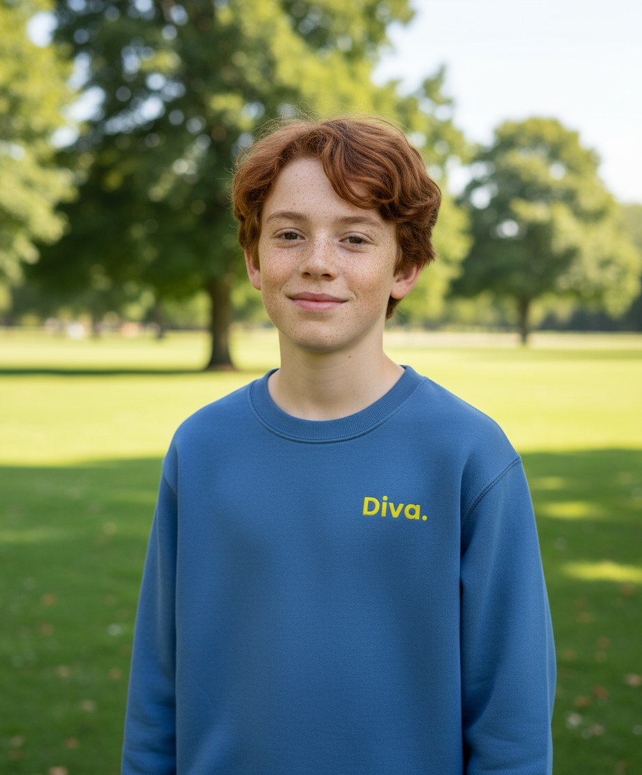 Young boy wearing a blue sweatshirt with 'Diva' text in a park setting