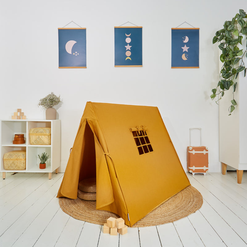 Children's play tent in ochre colour with a nine-paned window, displayed in a room setting with decorative items and wall hangings in the background.